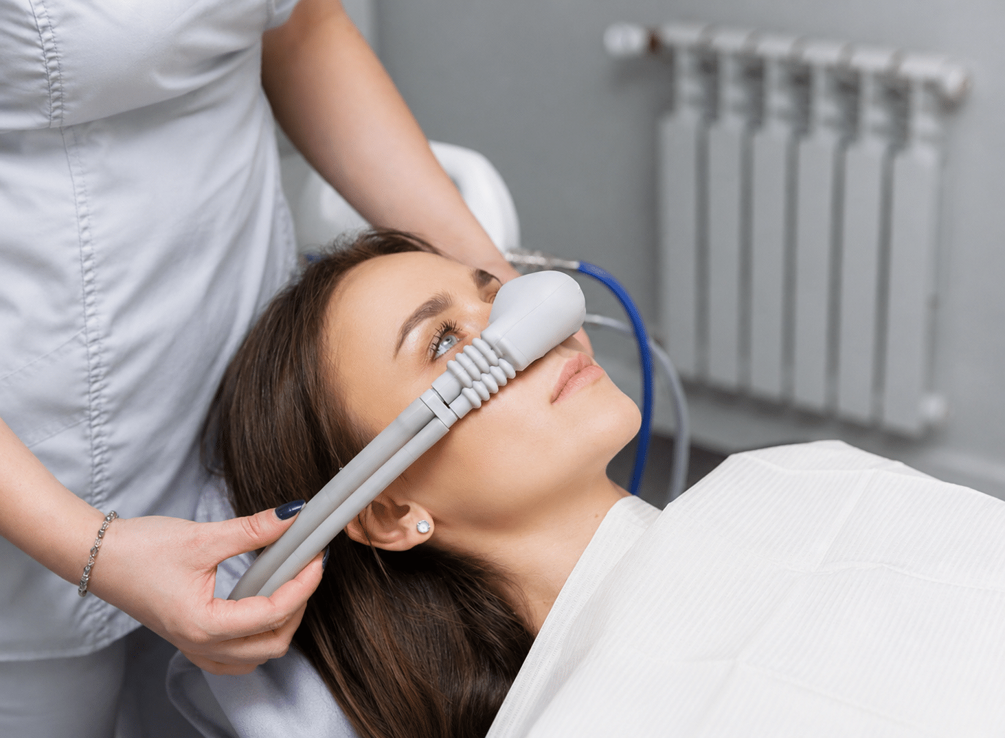 Dental patient having an inhalation tube placed over her nose as part of her sedation dentistry treatment.